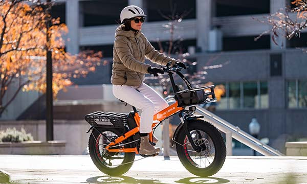 A girl who is wearing a helmet is riding a Mars 2.0 e-bike in the city